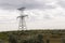 Heavy grey clouds in the cold autumn sky over green fields, trees, forests, streams. Before storm. Electric poles