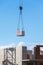 Heavy load hanging on construction site of brick building