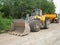 Heavy loader bulldozer bucket. Tractor loader with protective wheel chains on tyre