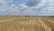 Heavy machinery on a massive wheat field, harvesting season, aerial footage