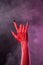 Heavy metal gesture, red devil hand with black nails