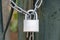 Heavy metal padlock with chain closeup on an entrance gate