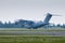 Heavy military transport turboprop aircraft touching the runway