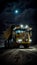 Heavy mining dump truck during night loading of rock in limestone quarry, stands on background of unsharp mine excavator