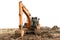 Heavy orange machine crawler loader or loader excavator, removing soil from ground, isolated on white background