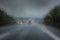 Heavy rain on the highway, thick drops on the windshield and blurred cars with red taillights on the dark road, dangerous weather