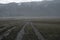 Heavy rain in mountains with gravel road. Cloud background. Mountain valley with rain clouds landscape.