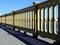 Heavy and rugged cast iron yellow color bridge railing with strong shadow