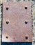 Heavy rusted steel plate with six bolts.