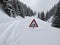 Heavy snowfall causes warning signs to sink into the pass road. Ski tour on the silver mountain. Winter landscape.