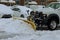 During a heavy snowfall, snowplow truck removes snow from parking lot