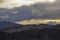 A heavy sunset sky over the desert mountain ranges