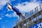 Heavy Tall Crane on Construction Site With Scaffolding, Blue Sky and Clouds