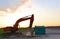 Heavy tracked excavator at a construction site on a background  sunset. Special heavy construction equipment for road construction