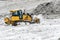 Heavy tractor with a bucket shovels snow removed from the road gshomme heaps