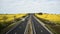 Heavy traffic on rural motorway among blooming rapeseed field