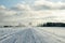 heavy truck is driving on a snowy and dusty road