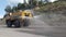 Heavy truck pours the road with water in the quarry. Irrigation dust removal, protection of the environment.