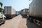 Heavy trucks loaded with goods trailers, parked in waiting area on state border crossing in Vietnam