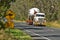 Heavy vehicle on a rural Victorian road, transporting a large tank.