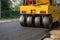 Heavy vibration yellow steamroller or soil compactor working on hot-mix asphalt pavement road