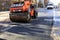 A heavy vibratory road roller compacts asphalt on the road to be repaired