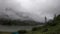 Heavy white clouds over a tourist tent near the lake, rainy weather.