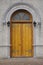 Heavy wooden arched door with ornate hinges