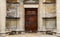 Heavy wooden double door outside of an old church with religious reliefs and inscriptions