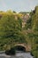 Hebden bridge town in summer with packhorse bridge crossing the river calder and stone buildings in summer with bright sky