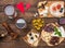 Ð¡heese board with grapes, nuts, fig, dates, olives, wine on rustic wooden background. Top view. Gourmet appetizer for romantic