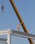 Height worker placing truss on building skeleton