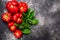 Heirloom ribbed  tomatoes and basil atop black textured backdrop, copy space, top view