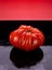 Heirloom Tomatoe on Black Wet Glass with Reflection Red Background