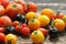 Heirloom variety tomatoes on rustic table. Colorful tomato - red,yellow , black, orange. Harvest vegetable cooking