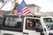 Helena, Montana - April 19, 2020: Man and woman hold American flags in a white jeep at a liberty rally around Capitol Square