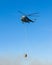 Helicopter in action carrying water bucket