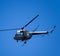 A helicopter of agricultural aviation is flying in the blue sky.