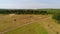 Helicopter arrived on green field. Helicopter landed on yellow grass, cloudy day. Flying drone and green wheat field