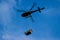 Helicopter with blurred blades carrying loads