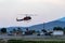 Helicopter flies a bucket of water to a nearby California wildfire to put out the fire