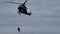 Helicopter in hovering flight descends with winch rescuers. Extreme bad weather