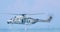 Helicopter in hovering over the water drops soldiers. Grey modern Italian Navy NHIndustries NH90