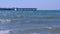 Helicopter platform and pier at sea and stormy sea waves at windy day.