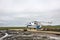 A helicopter sits on a wooden heliport in the tundra.