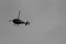 Helicopter soaring in the gray sky