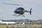 Helicopter takes off over a busy airfield