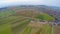 Helicopter view of green farmland and houses in countryside. Agricultural fields