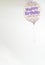 a helium balloon decorated with colored dots and a happy birthday message, with a hanging ribbon, copy space