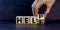 Hell or help symbol. Businessman turns a cube and changes the word `hell` to `help`. Business, psychology and hell or help con